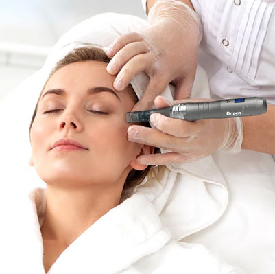 An image featuring a woman lying on a massage table with her eyes closed, receiving a facial treatment or therapy from a professional using a device that appears to be a handheld vacuum or suction tool.