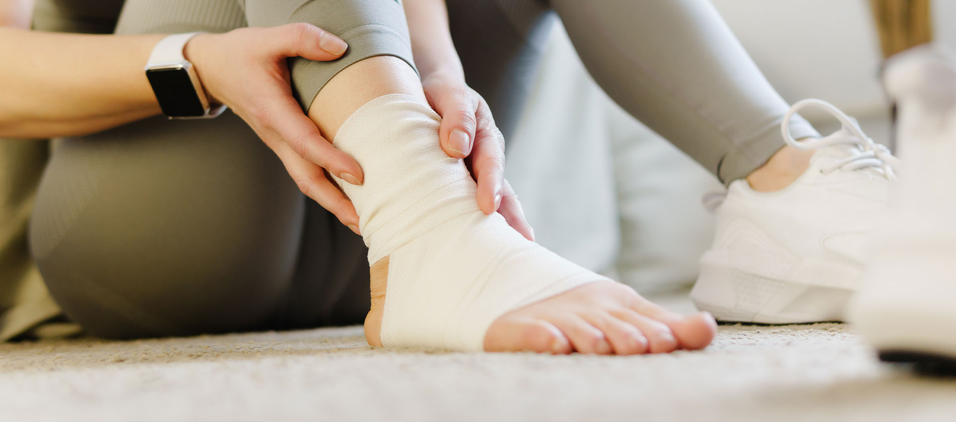 An image of a person s lower leg and foot, featuring a bandage wrapped around the ankle.