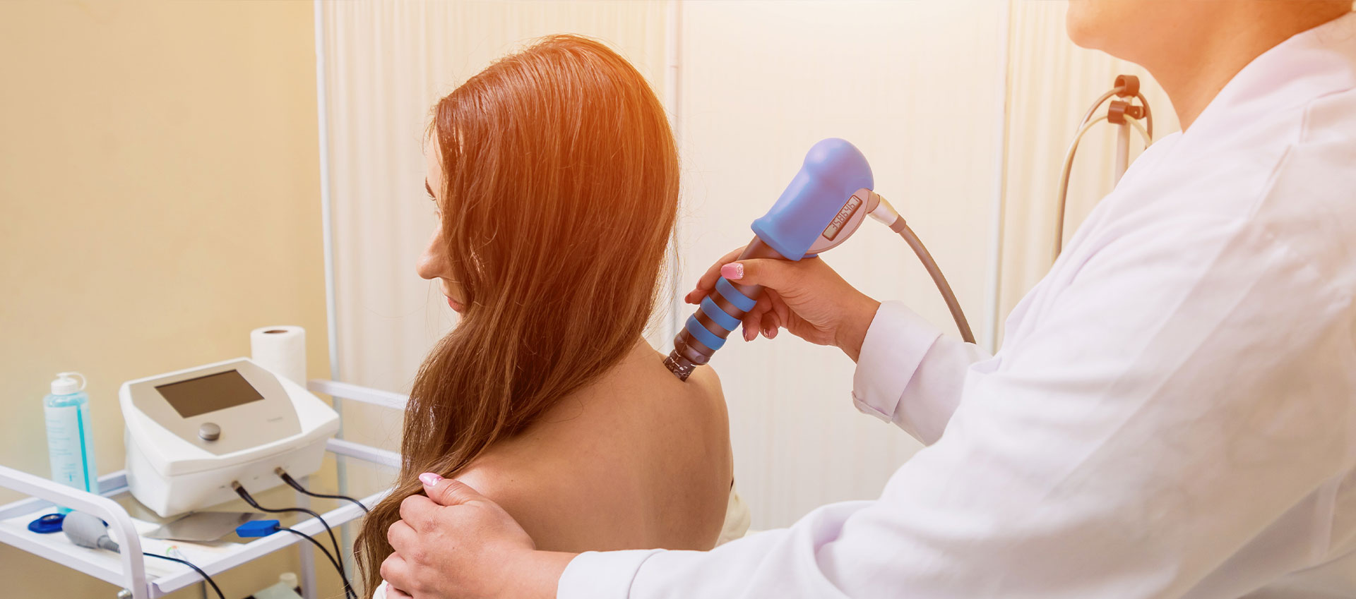 The image shows a person lying on a massage table with their back exposed, receiving a massage from someone standing over them.