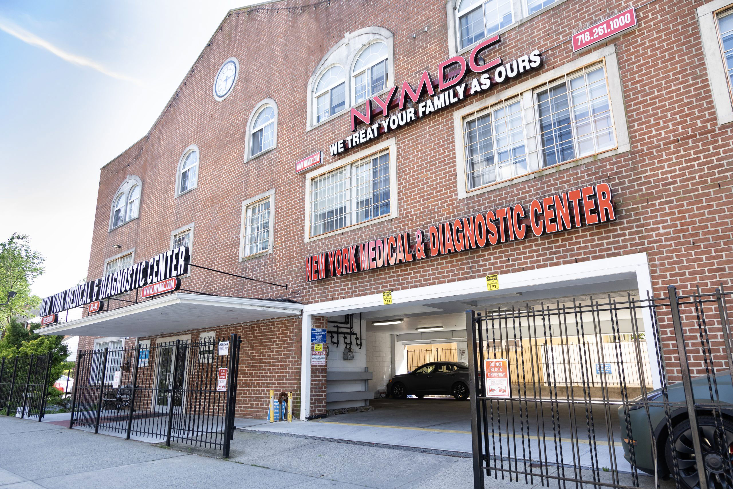 The image shows a building with signage indicating it is a medical facility, including a sign for an 'NYC Diagnostic Center' and a sign that reads 'Welcome to our family.